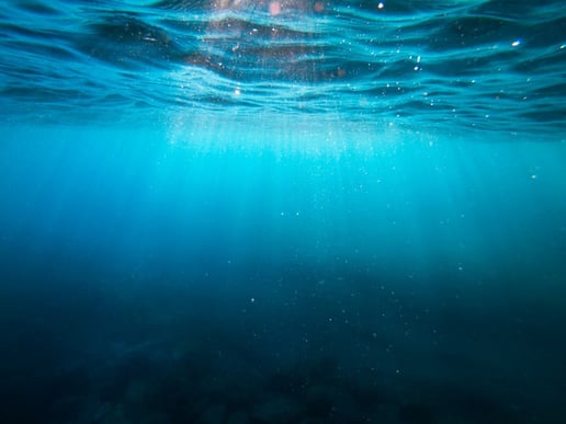 Sunlight shining down through deep blue water